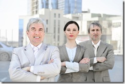 Portrait of three business people outside.