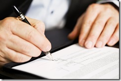 Close up of businessman signing a contract.